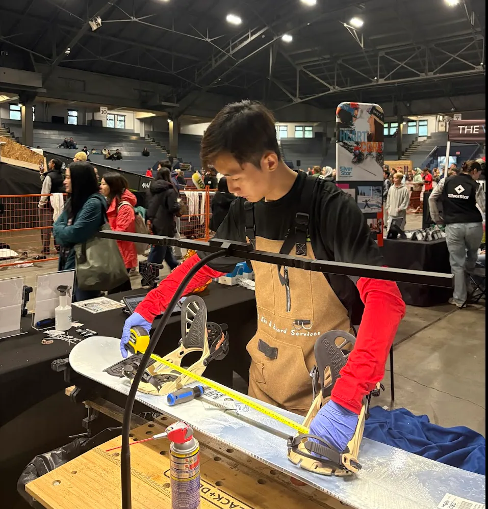 EZ Ski and Board technician checking a snowboard at a public event